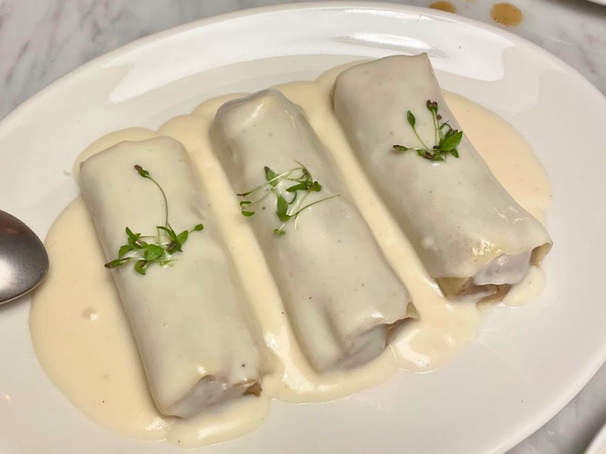Traditional Catalan canelons filled with meat and topped with creamy béchamel sauce