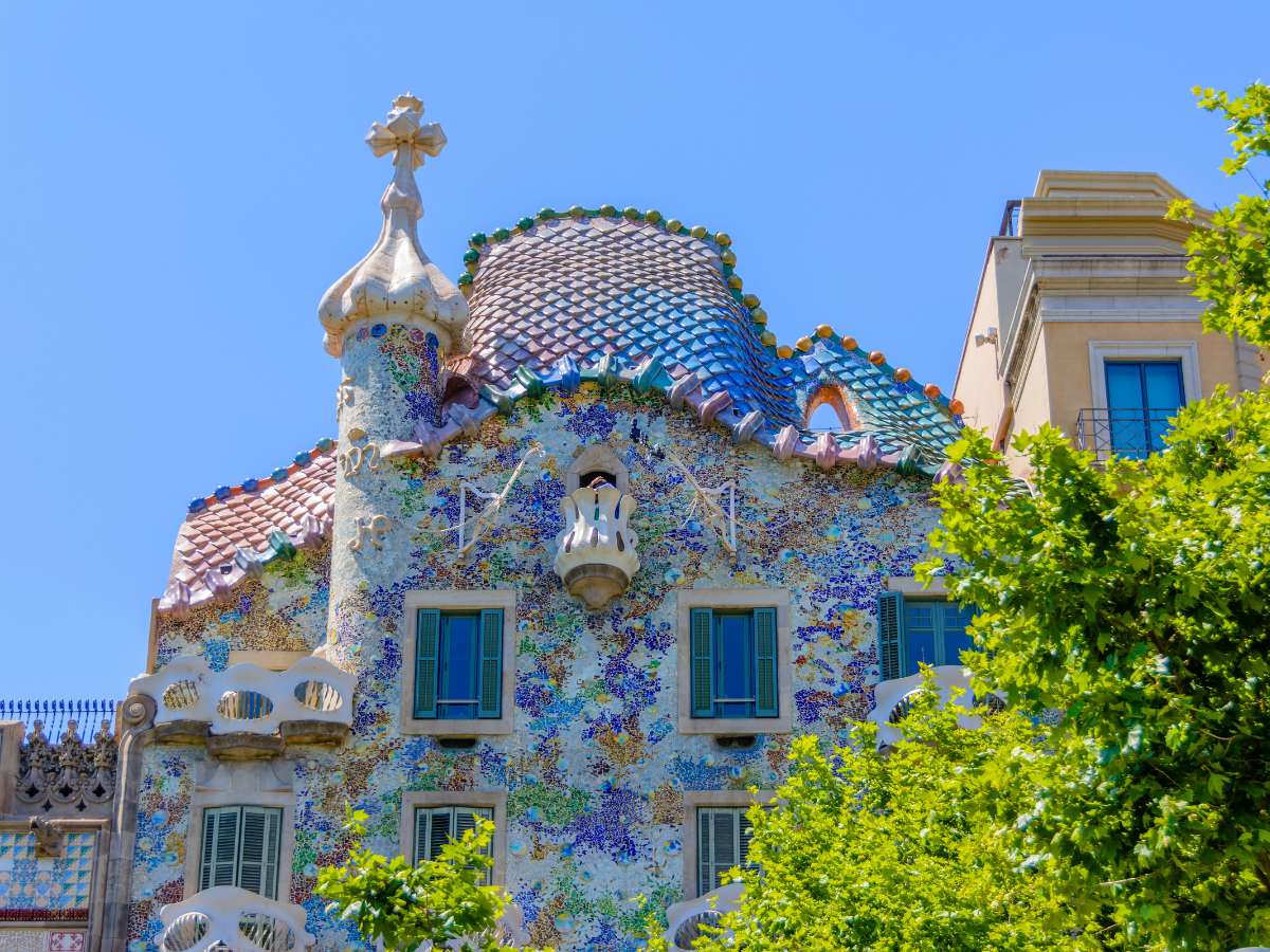 A view of the exterior of Casa Batllo with colorful scales and modernist architecture
