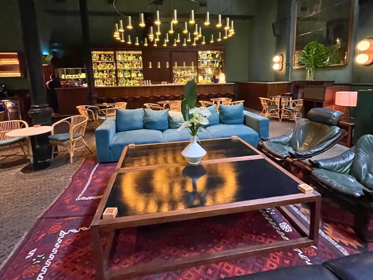 Stylish lounge and bar area inside Casa Bonay hotel in Barcelona with blue sofas, leather chairs, and modern lighting