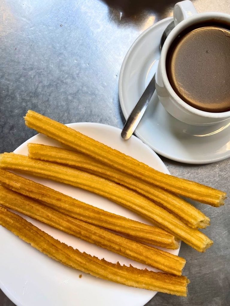 Churros served with a cup of thick hot chocolate at a café in Spain