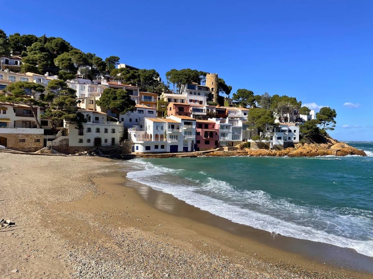 Seaside houses and beach at Sa Tuna in Begur with waves along the shore
