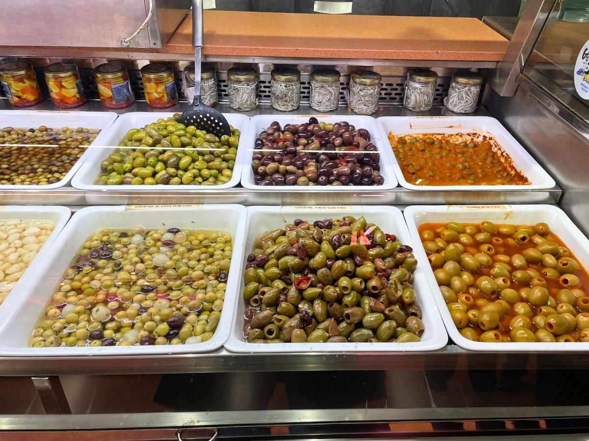 Large dishes of olive varieties at a local market in Spain