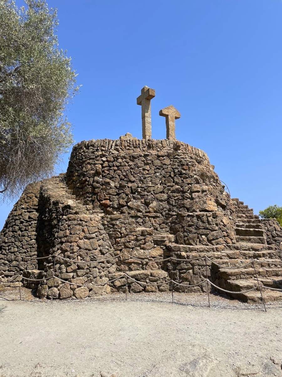 Three Crosses monument on a stone hilltop at Park Güell in Barcelona