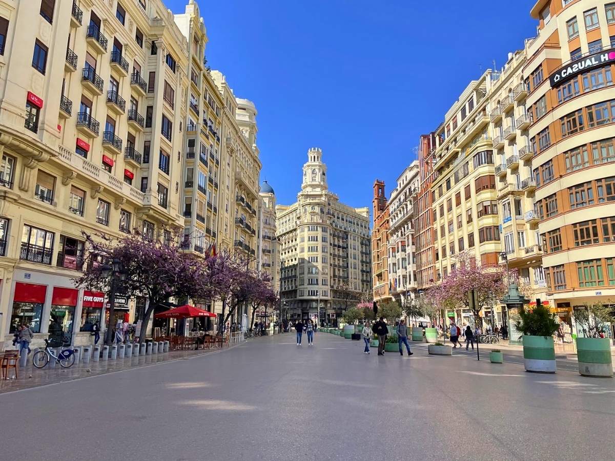 People walking through a plaza in Valencia Spain surrounded by historic buildings