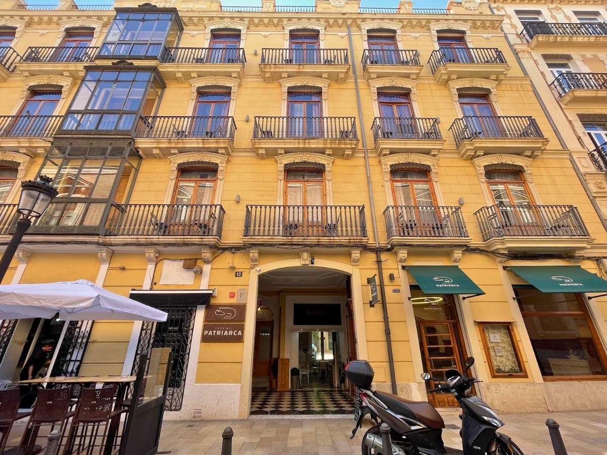 The exterior facade of Casa del Patriarca hotel in Valencia Spain with wrought iron balconies