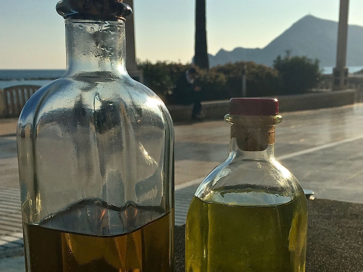 Bottles of traditional Spanish orujo on a table overlooking the coast and mountains