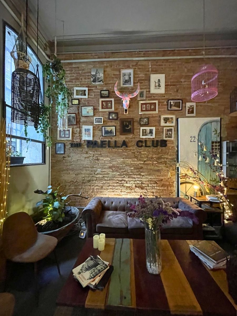 The sitting area at the front of the Paella Club with a couch and decorative frames