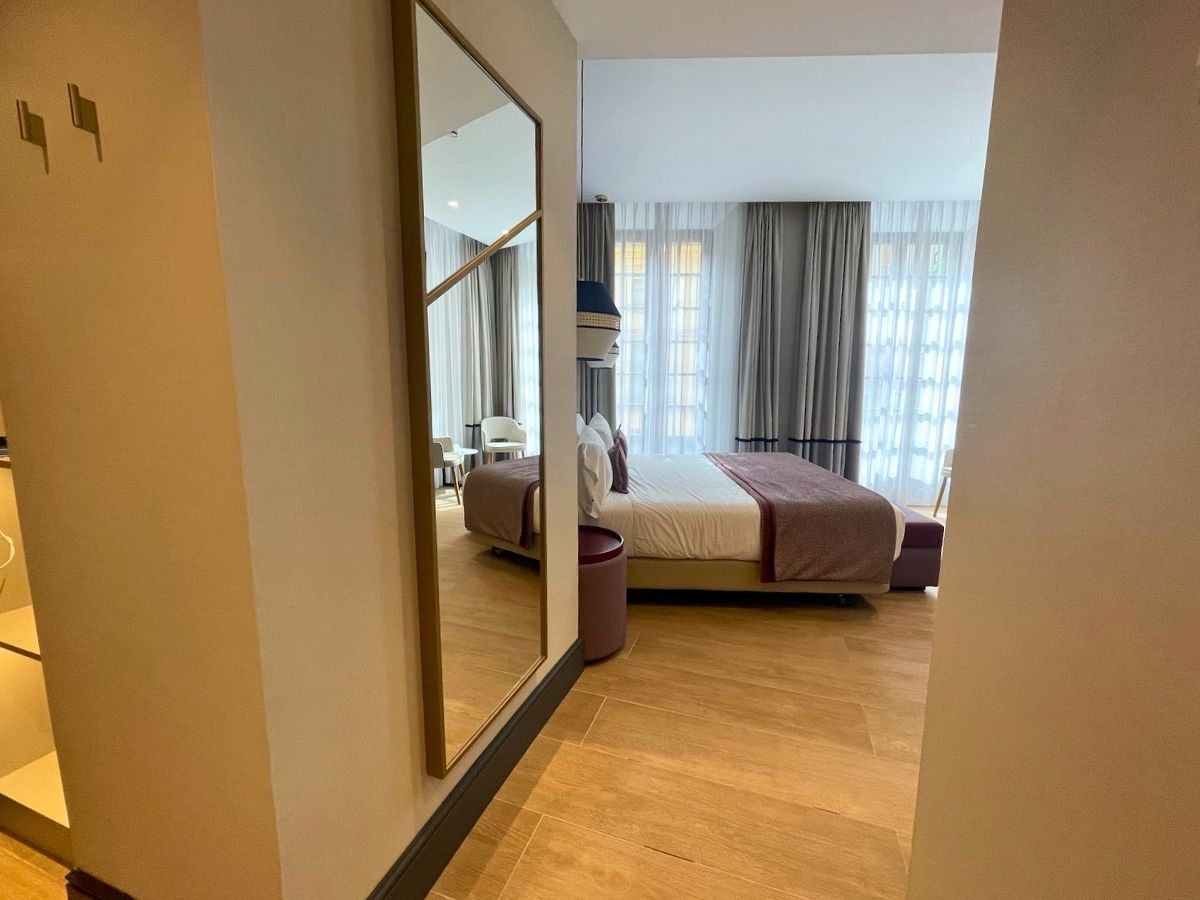 Entryway view of a guest room at Hotel Catalonia Puerta del Mar featuring a full-length mirror and floor-to-ceiling windows