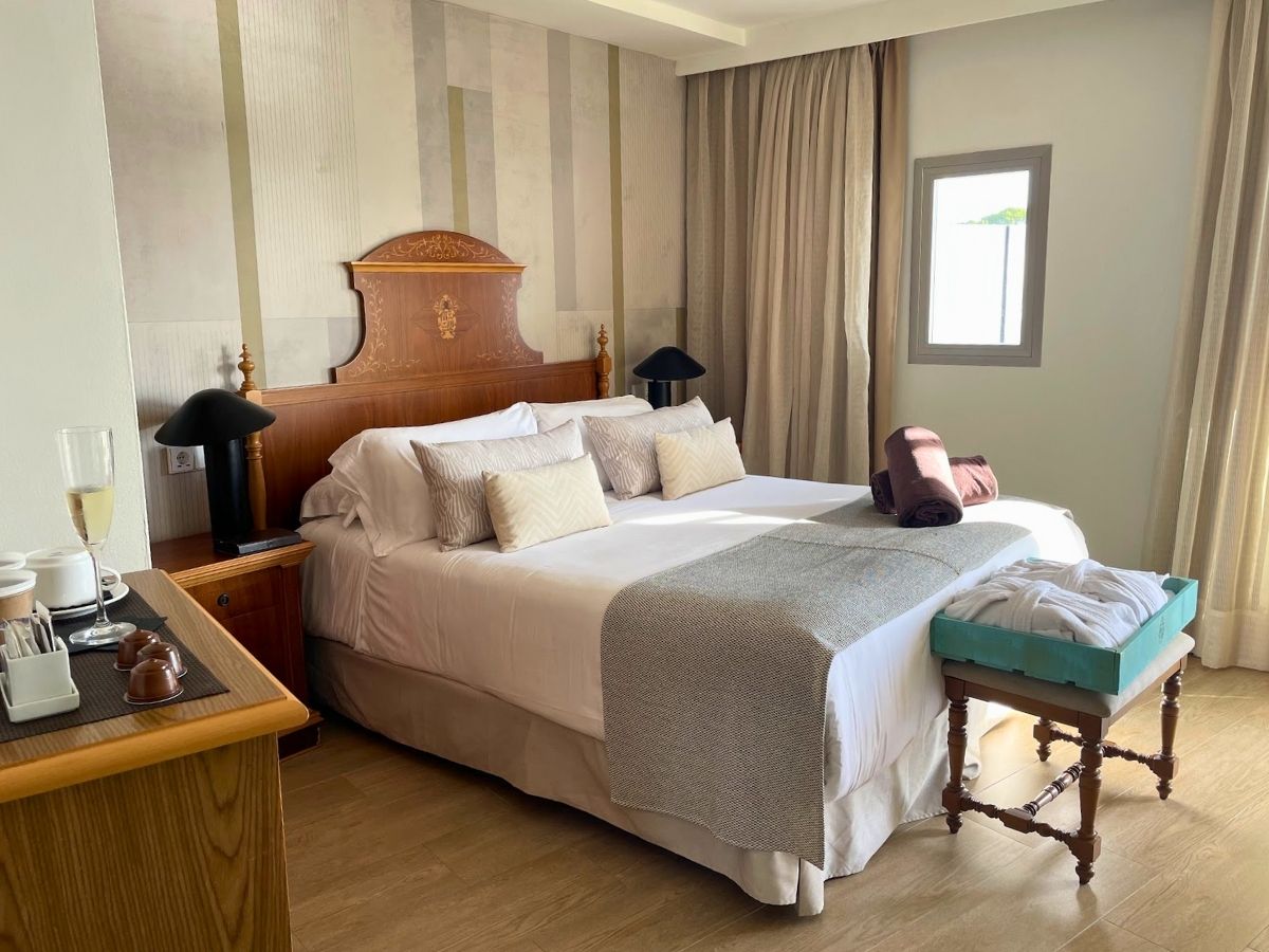 Elegant guest room at Secrets Mallorca Villamil with a plush king bed, wooden headboard, and modern decor