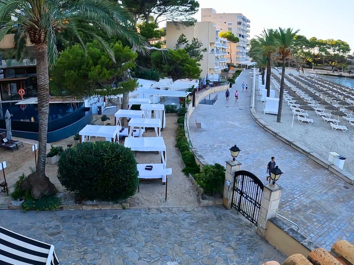 Elevated view of the beachfront walkway and canopy daybeds next to Secrets Mallorca Villamil’s outdoor lounging area