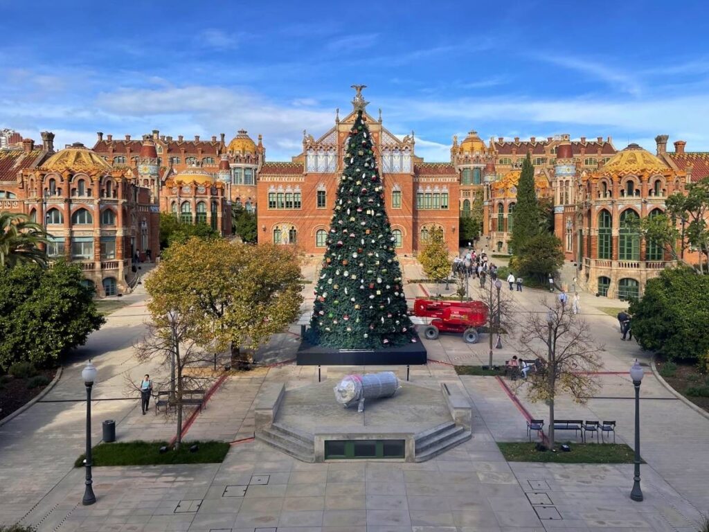 Large decorated Christmas tree in front of the historic Sant Pau Art Nouveau Site in Barcelona on a sunny winter day