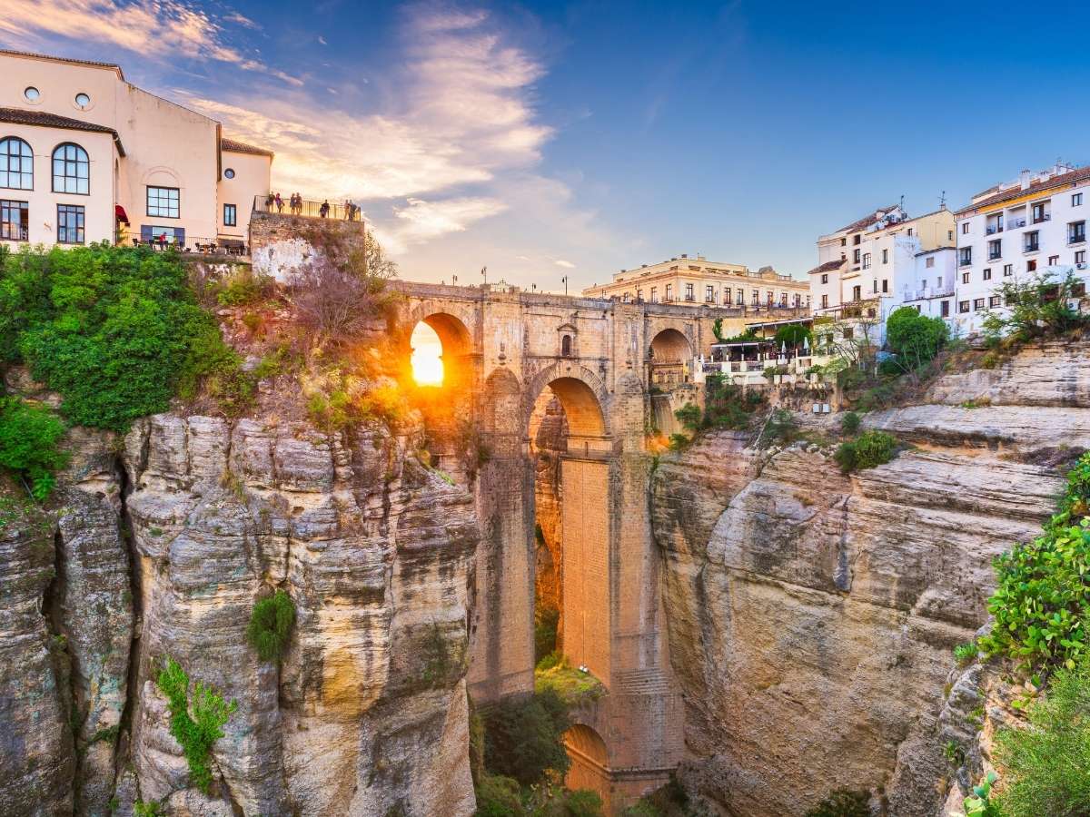 Dramatic cliffside view of Puente Nuevo bridge at sunset in Ronda
