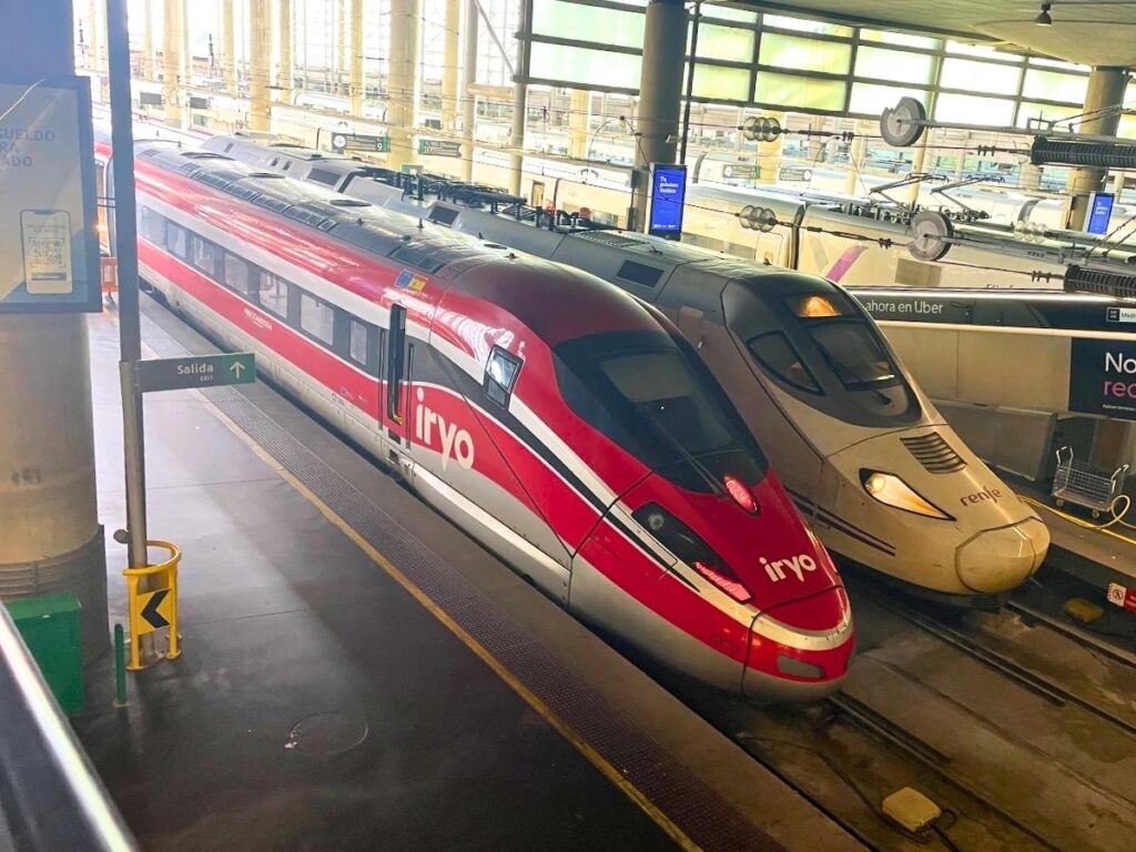 Iryo and Renfe high speed trains parked side by side at a station in Spain
