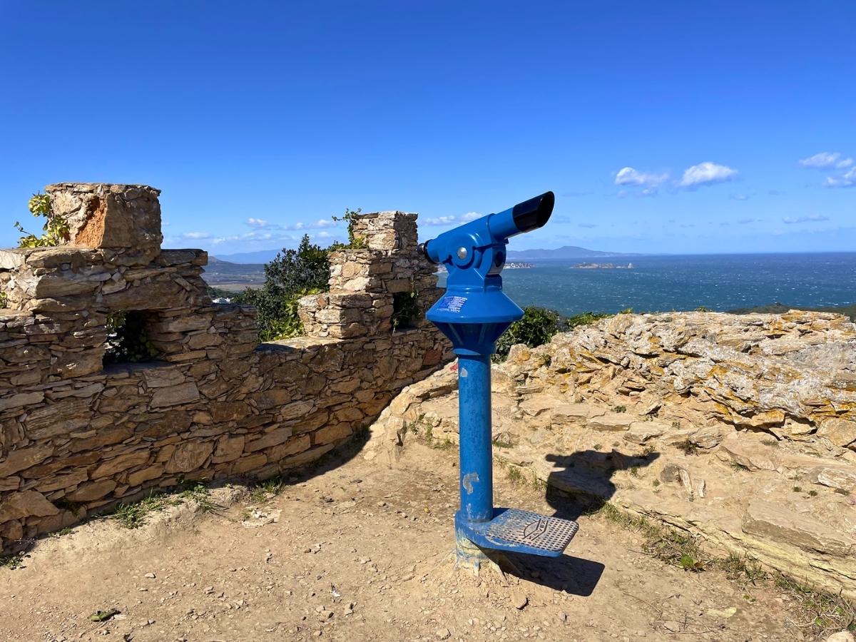 Scenic viewpoint from Begur Castle with a blue telescope overlooking the coastline and sea