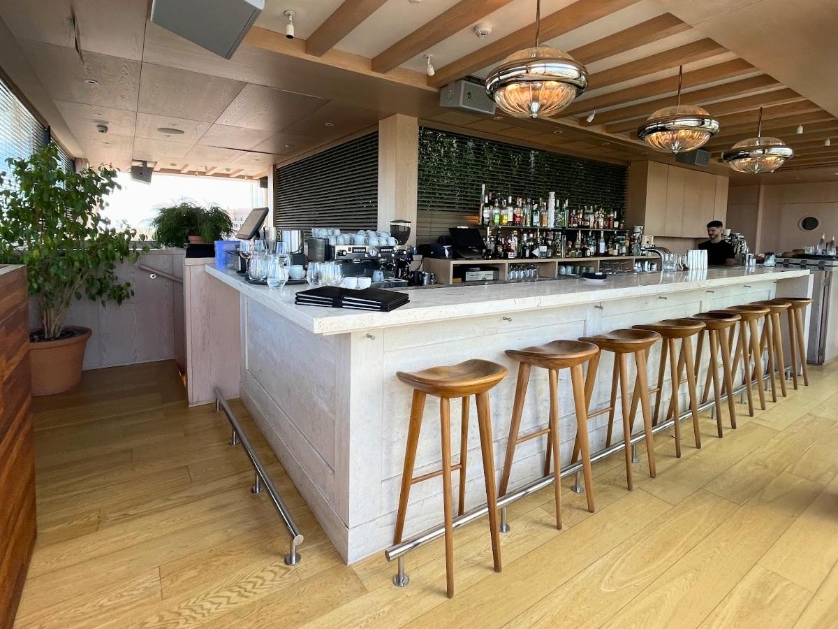 Bar area at The Barcelona EDITION with marble counter, wooden stools, and modern design