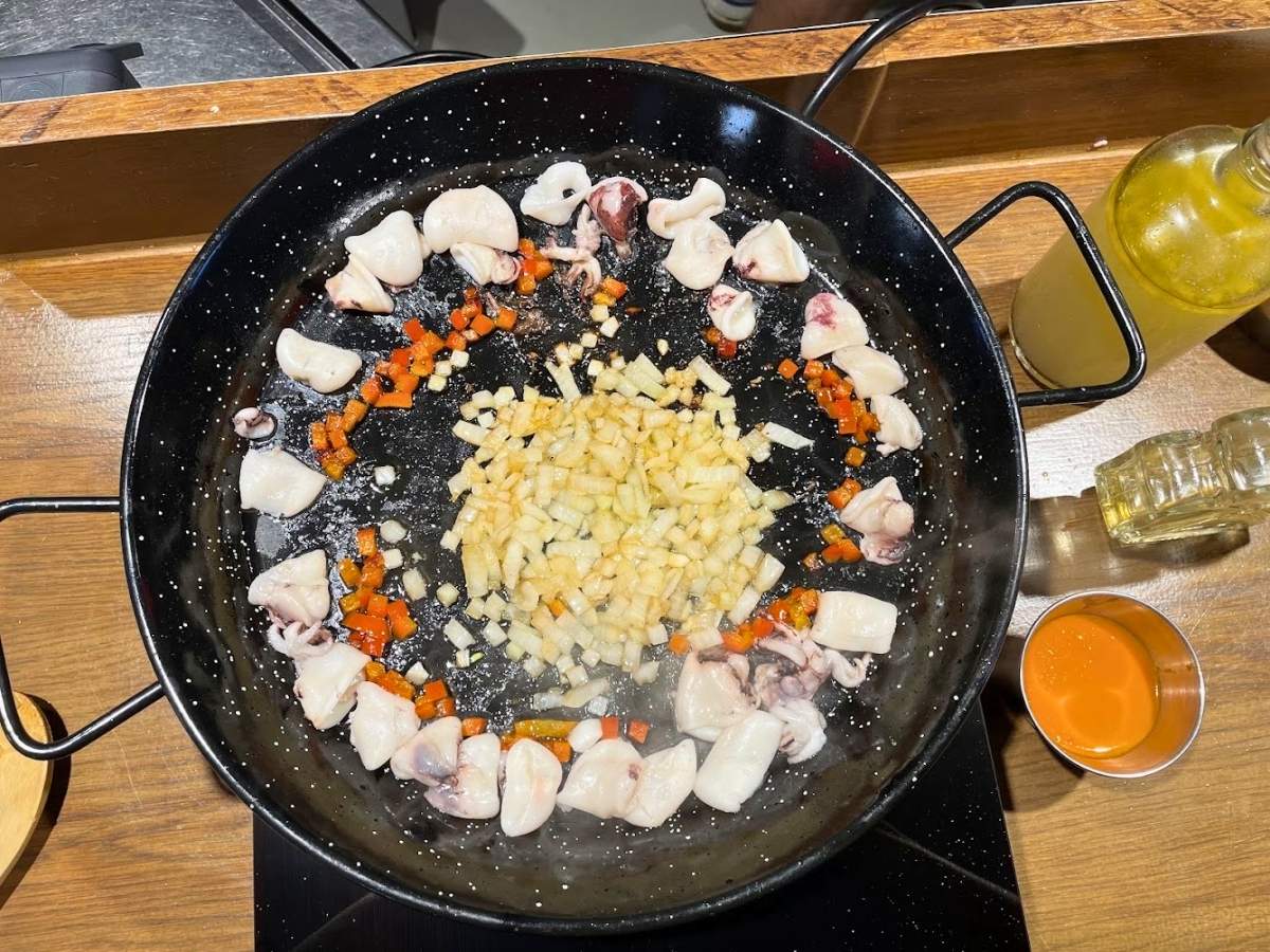 Seafood and vegetables cooking in a paella pan at Rice to Meet You in Barcelona