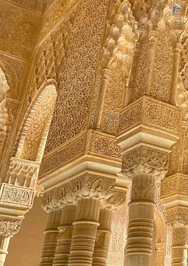 Detailed carvings, arches, and columns inside the Alhambra palace in Granada