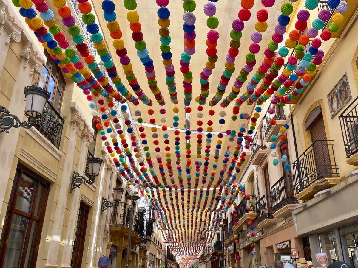 Colorful decorations hanging above Carrera Espinel shopping street in Ronda