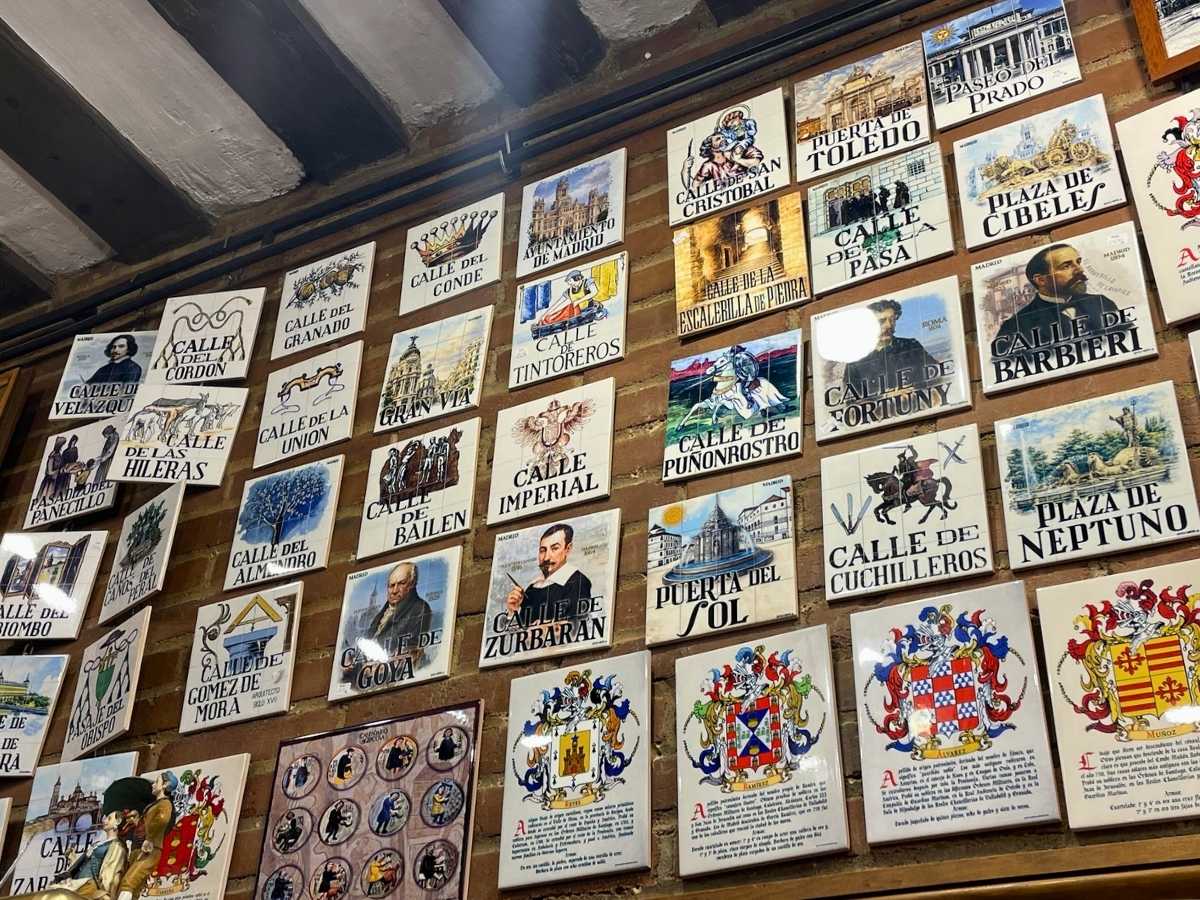 Decorative ceramic tiles featuring Madrid street signs and landmarks at Gritos de Madrid