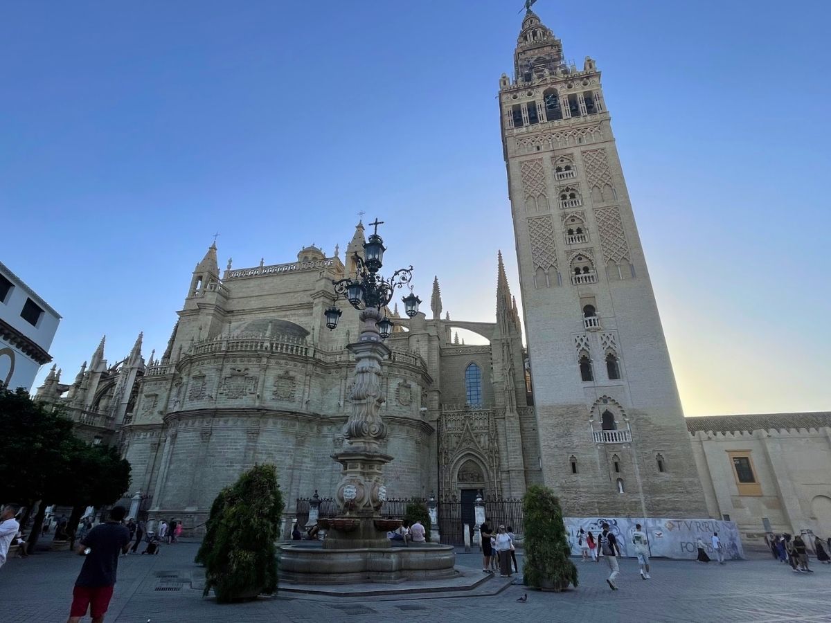 Seville Cathedral and La Giralda bell tower overlooking a plaza with a decorative fountain