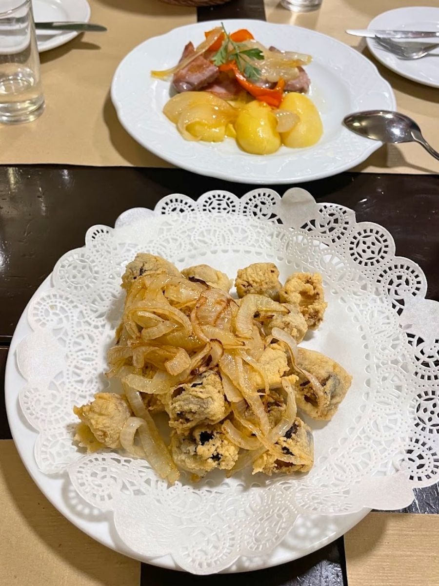 Plates of fried cazón with onions and tuna with potatoes served at a restaurant in Seville
