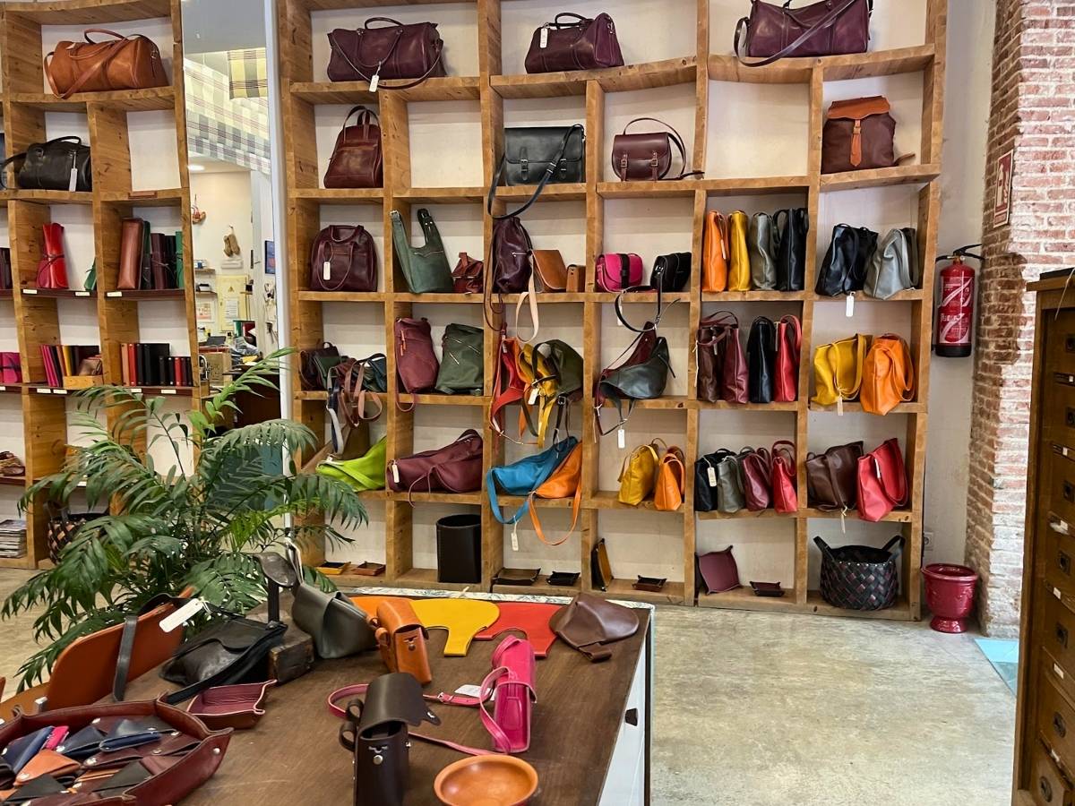 Colorful leather bags, wallets, and accessories displayed inside Taller Puntera in Madrid